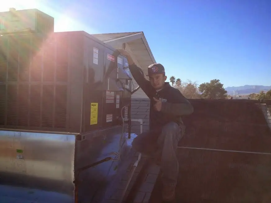 HVAC technician performing AC Tune-Up on a rooftop unit in Seal Beach